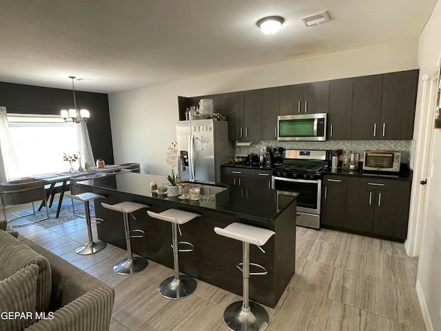 kitchen featuring a breakfast bar area, a center island, decorative light fixtures, and stainless steel appliances