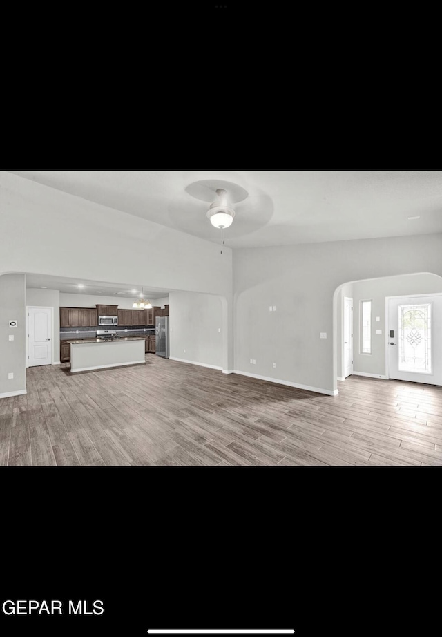 unfurnished living room featuring light wood-type flooring and ceiling fan