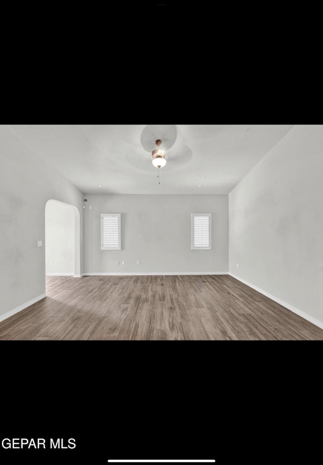 unfurnished room featuring a healthy amount of sunlight, wood-type flooring, and ceiling fan