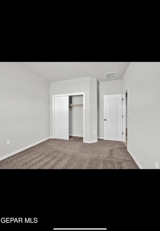 unfurnished bedroom with a closet and carpet