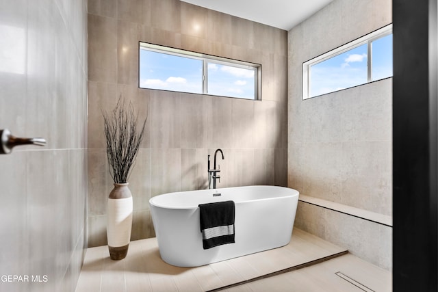 bathroom featuring tile walls and a washtub