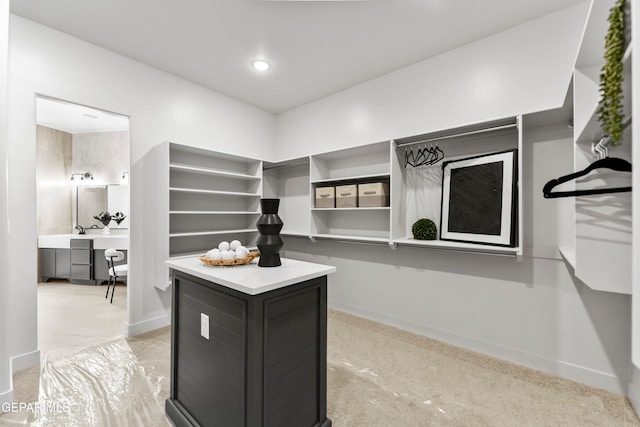 walk in closet with built in desk and light colored carpet