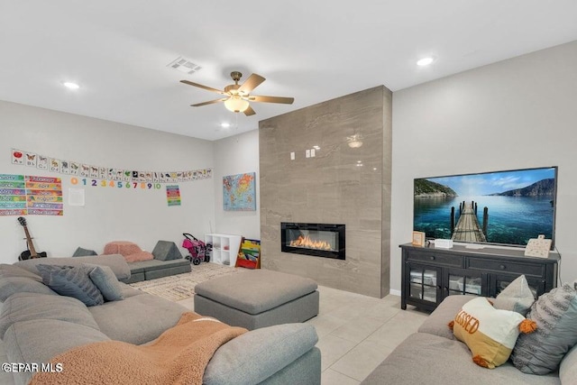 living room with a fireplace, light tile patterned floors, and ceiling fan