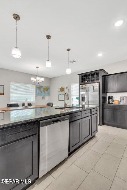 kitchen featuring hanging light fixtures, sink, light tile patterned flooring, a notable chandelier, and appliances with stainless steel finishes