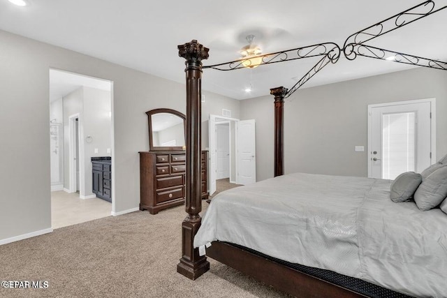 bedroom featuring ensuite bathroom and light colored carpet