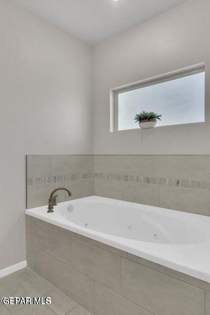 bathroom featuring tile patterned flooring and tiled tub