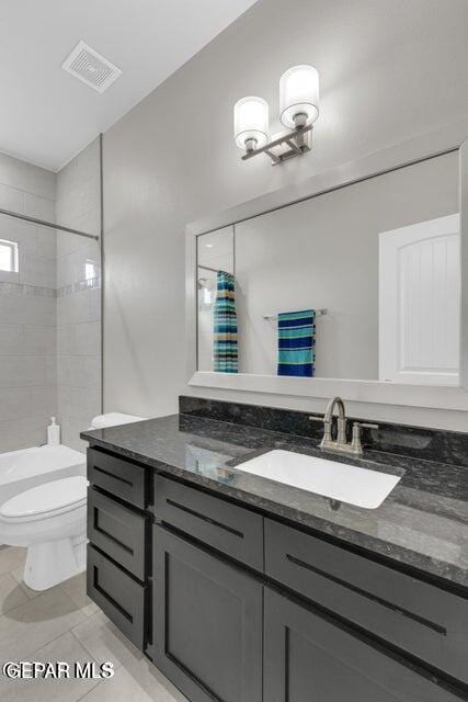 full bathroom featuring vanity, shower / tub combo with curtain, toilet, and tile patterned flooring