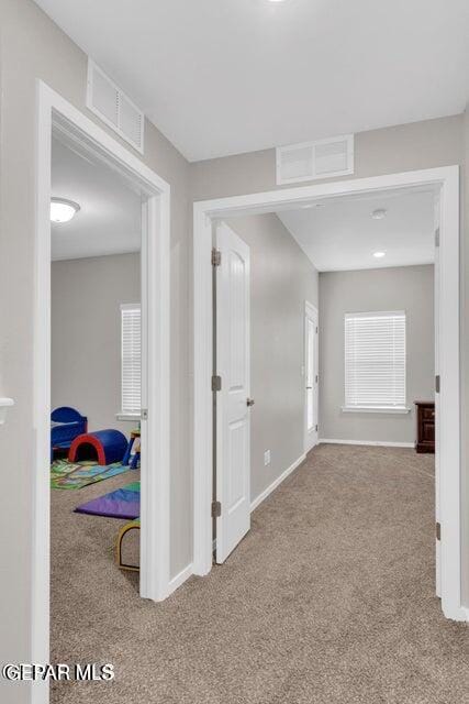 corridor featuring light colored carpet