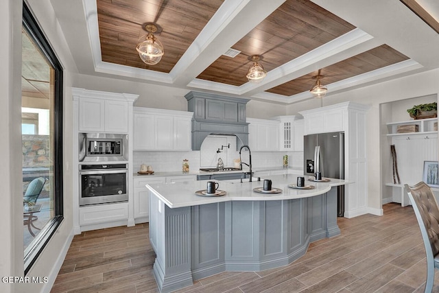 kitchen with an island with sink, white cabinetry, stainless steel appliances, wooden ceiling, and light hardwood / wood-style flooring