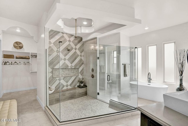 bathroom featuring vanity, plus walk in shower, and tile patterned floors