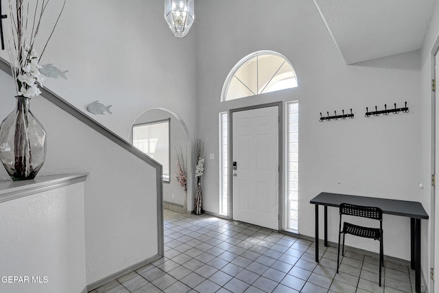 tiled entrance foyer featuring a towering ceiling