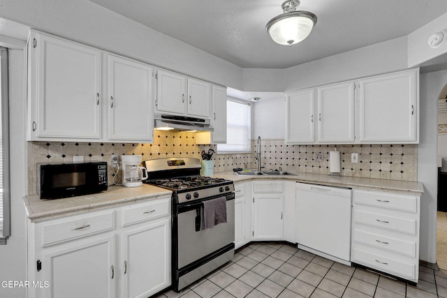 kitchen featuring gas range oven, white cabinetry, and white dishwasher