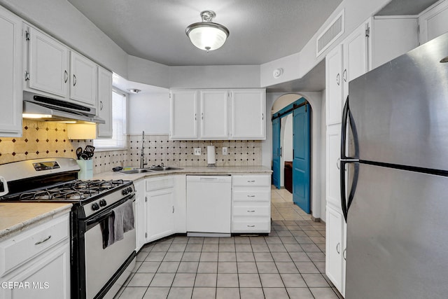 kitchen with decorative backsplash, white cabinetry, sink, and white appliances