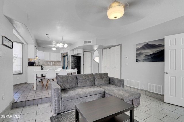 tiled living room featuring an inviting chandelier