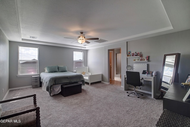 bedroom with ceiling fan, a textured ceiling, multiple windows, and light colored carpet