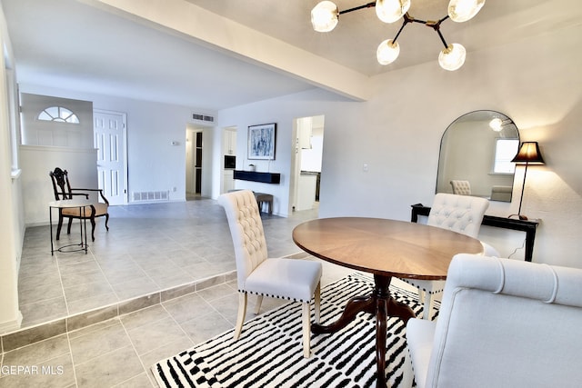 tiled dining space featuring a notable chandelier