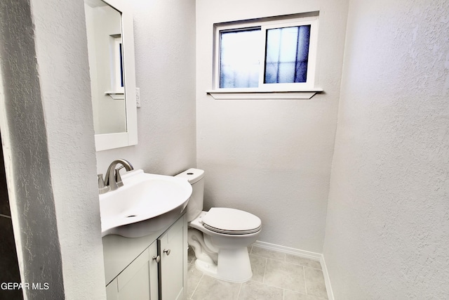 bathroom featuring tile patterned flooring, vanity, and toilet