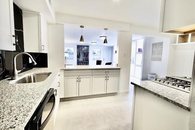 kitchen featuring a wealth of natural light, sink, white cabinets, and decorative light fixtures