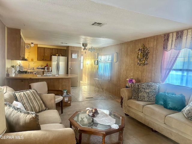 living room with wood walls and a textured ceiling