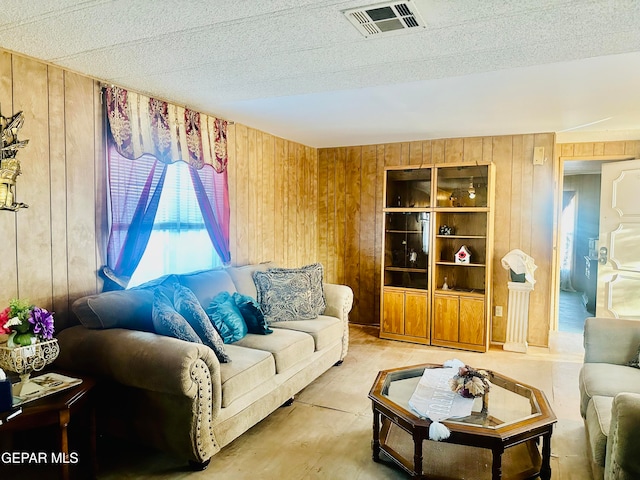 living room with a textured ceiling and wooden walls