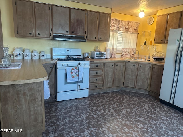 kitchen featuring kitchen peninsula, sink, and white appliances