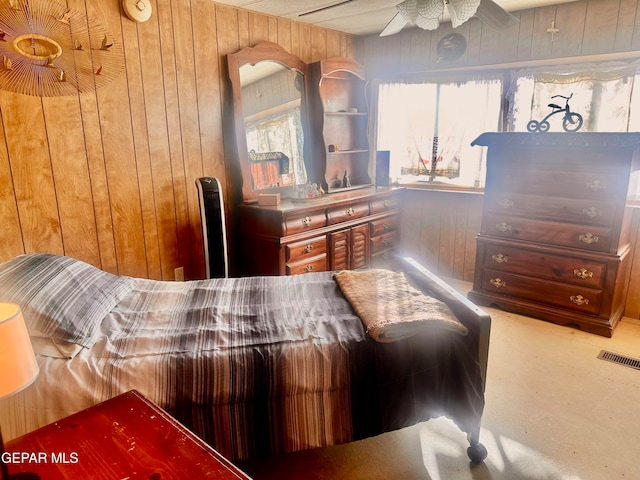 carpeted bedroom with wood walls and ceiling fan