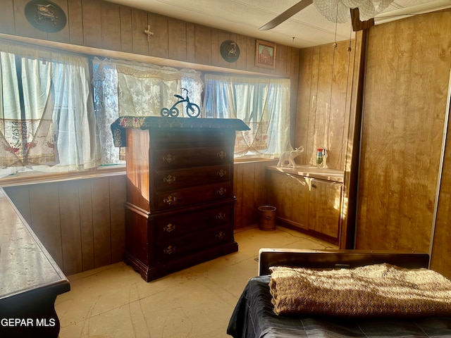 bedroom featuring wood walls and ceiling fan