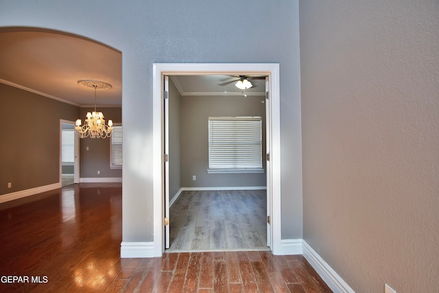 hall with crown molding, hardwood / wood-style flooring, and a chandelier