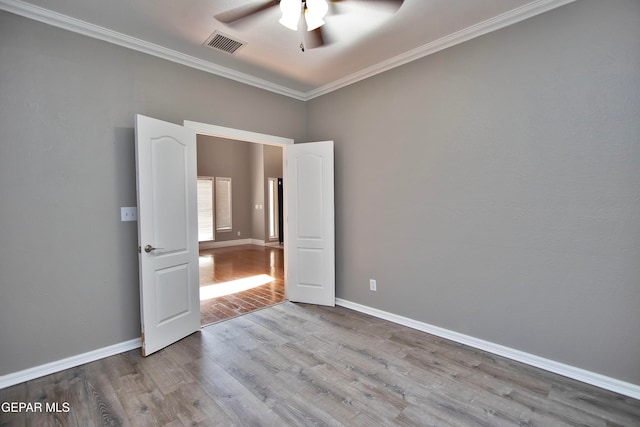 spare room featuring ceiling fan, ornamental molding, and light wood-type flooring