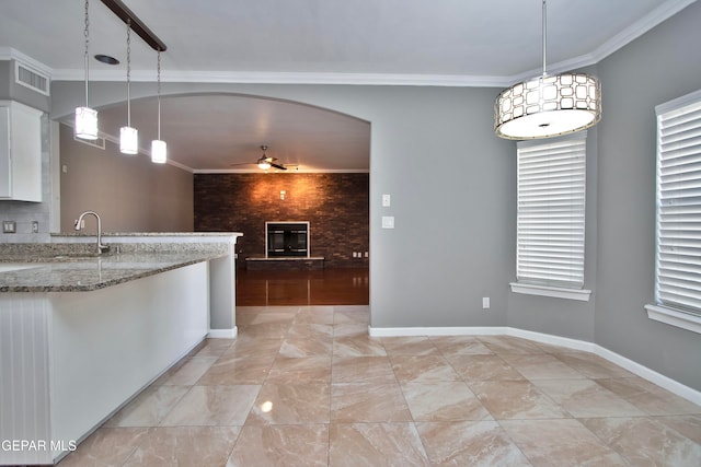 kitchen featuring white cabinets, light stone counters, decorative light fixtures, and ceiling fan