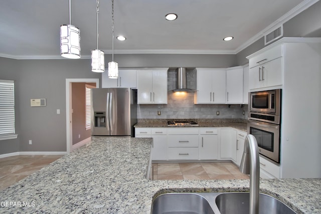 kitchen featuring wall chimney range hood, sink, white cabinetry, appliances with stainless steel finishes, and light stone counters