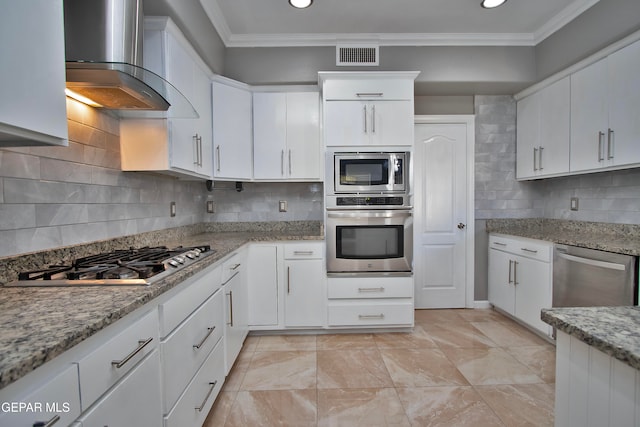 kitchen with decorative backsplash, wall chimney exhaust hood, white cabinetry, and stainless steel appliances