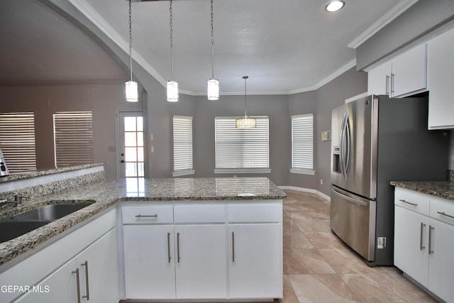 kitchen with stainless steel fridge, white cabinets, and pendant lighting