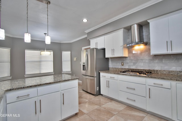 kitchen with hanging light fixtures, appliances with stainless steel finishes, white cabinetry, crown molding, and wall chimney exhaust hood