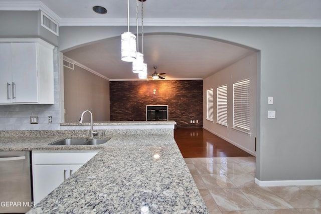 kitchen with stainless steel dishwasher, white cabinets, sink, and hanging light fixtures