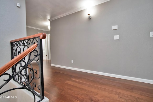 stairs with ornamental molding and hardwood / wood-style floors