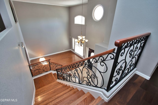 stairway with a chandelier and wood-type flooring