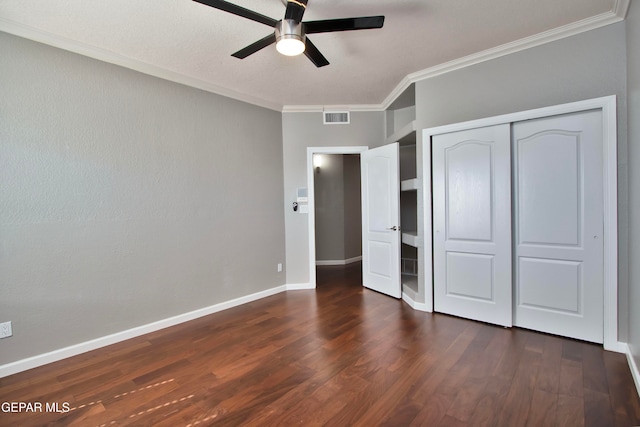 unfurnished bedroom featuring a closet, crown molding, ceiling fan, and dark hardwood / wood-style flooring