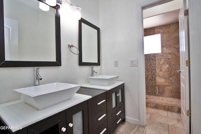 bathroom with vanity, a tile shower, and tile patterned flooring