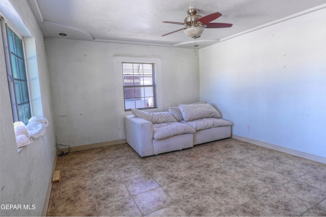 living room featuring a textured ceiling and ceiling fan