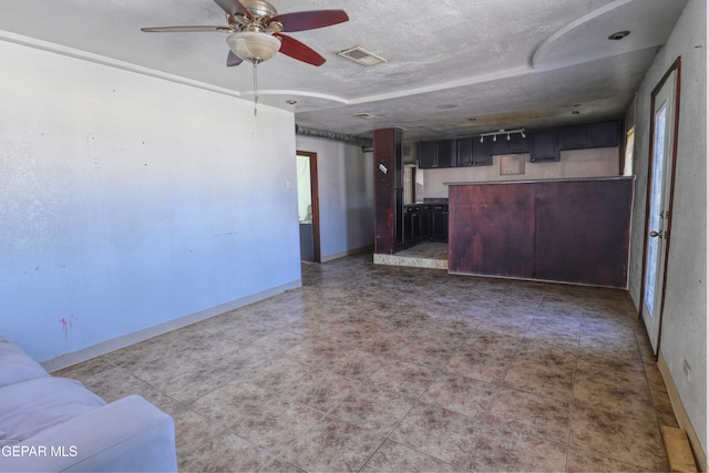 unfurnished living room featuring a textured ceiling and ceiling fan