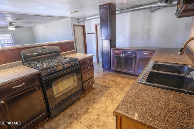 kitchen featuring ceiling fan, light tile patterned floors, a textured ceiling, black range with gas cooktop, and sink