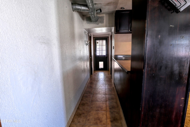 corridor featuring dark tile patterned floors