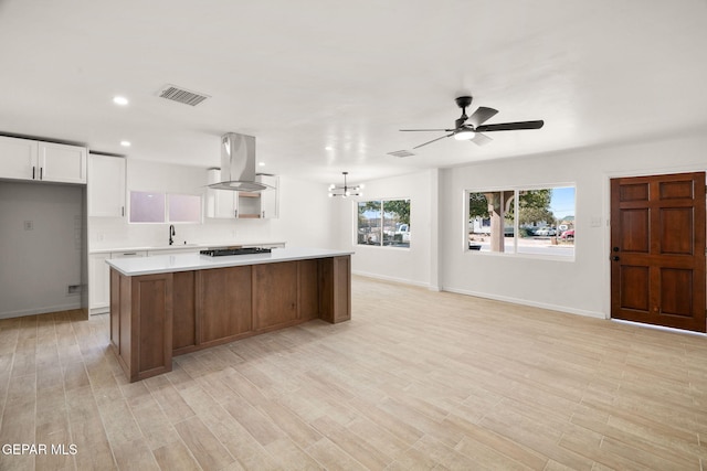 kitchen featuring white cabinetry, island exhaust hood, a center island, and light hardwood / wood-style floors