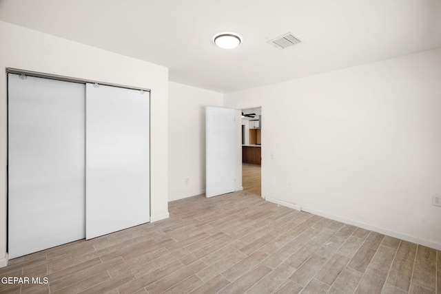 unfurnished bedroom featuring a closet and light wood-type flooring