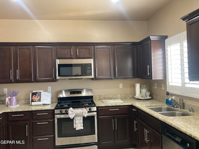 kitchen with dark brown cabinets, stainless steel appliances, and sink