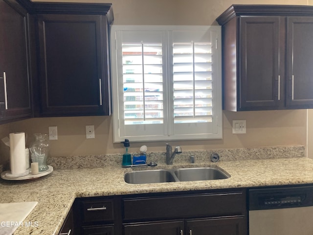 kitchen with dishwasher, sink, and light stone counters