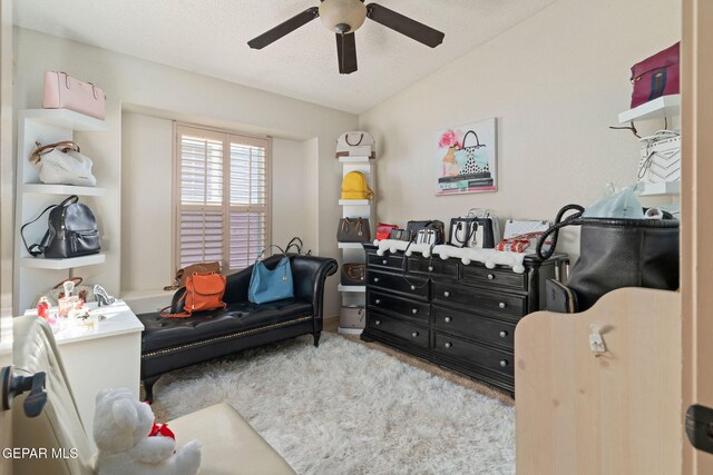 interior space with lofted ceiling, a textured ceiling, and ceiling fan