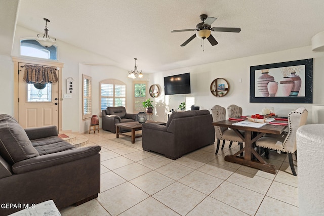 living room featuring lofted ceiling, a textured ceiling, light tile patterned flooring, and ceiling fan with notable chandelier