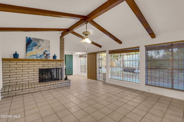 unfurnished living room with ceiling fan, lofted ceiling with beams, light tile patterned floors, and a fireplace